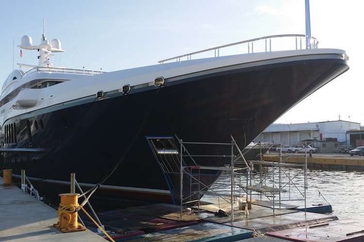 Yacht anchored in the shipyard with scaffolding in the stern of the boat