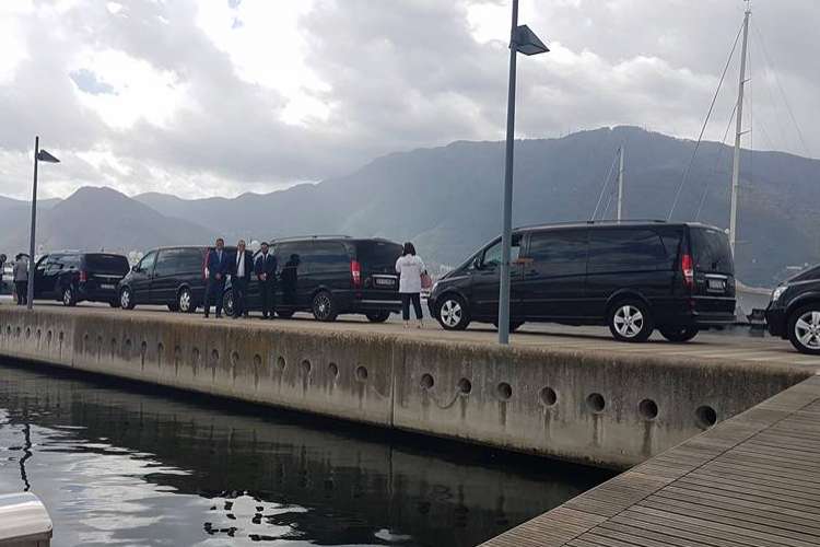 Black Mercedes vans parked in a port.
