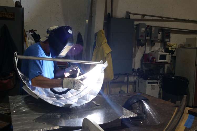 Man welding in a Thunderbolt Marine metal workshop